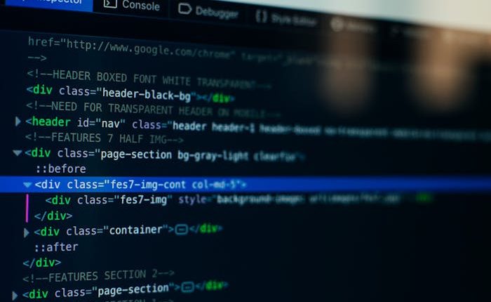 A close-up photo of a computer screen showing HTML code in the 'Inspector' panel of a browser's developer tools. The code is on a dark background, and one 'div' tag is highlighted in blue, indicating it is selected.