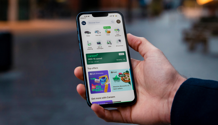 Person holding a smartphone displaying the Careem app interface, showcasing various services such as ride-hailing, food delivery, groceries, and top offers in a clean and user-friendly layout