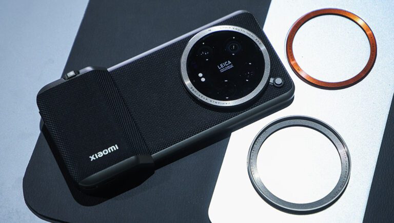 Xiaomi smartphone with a Leica-engineered circular camera module, placed on a display table alongside two interchangeable lens filters, designed to resemble a high-end compact digital camera