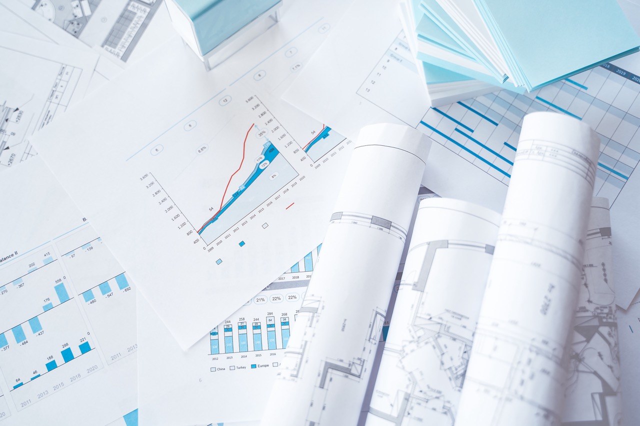 Business project documentation, development, planning and approval. Construction drawings for building, apartment, financial diagrams, investment plan, documents. Making repairs. Blurred background.