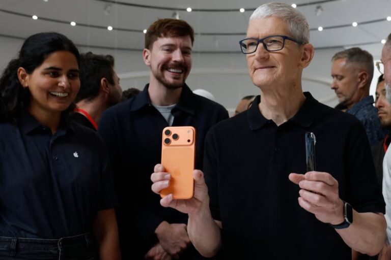 Tim Cook, CEO of Apple, holding up the new iPhone 17